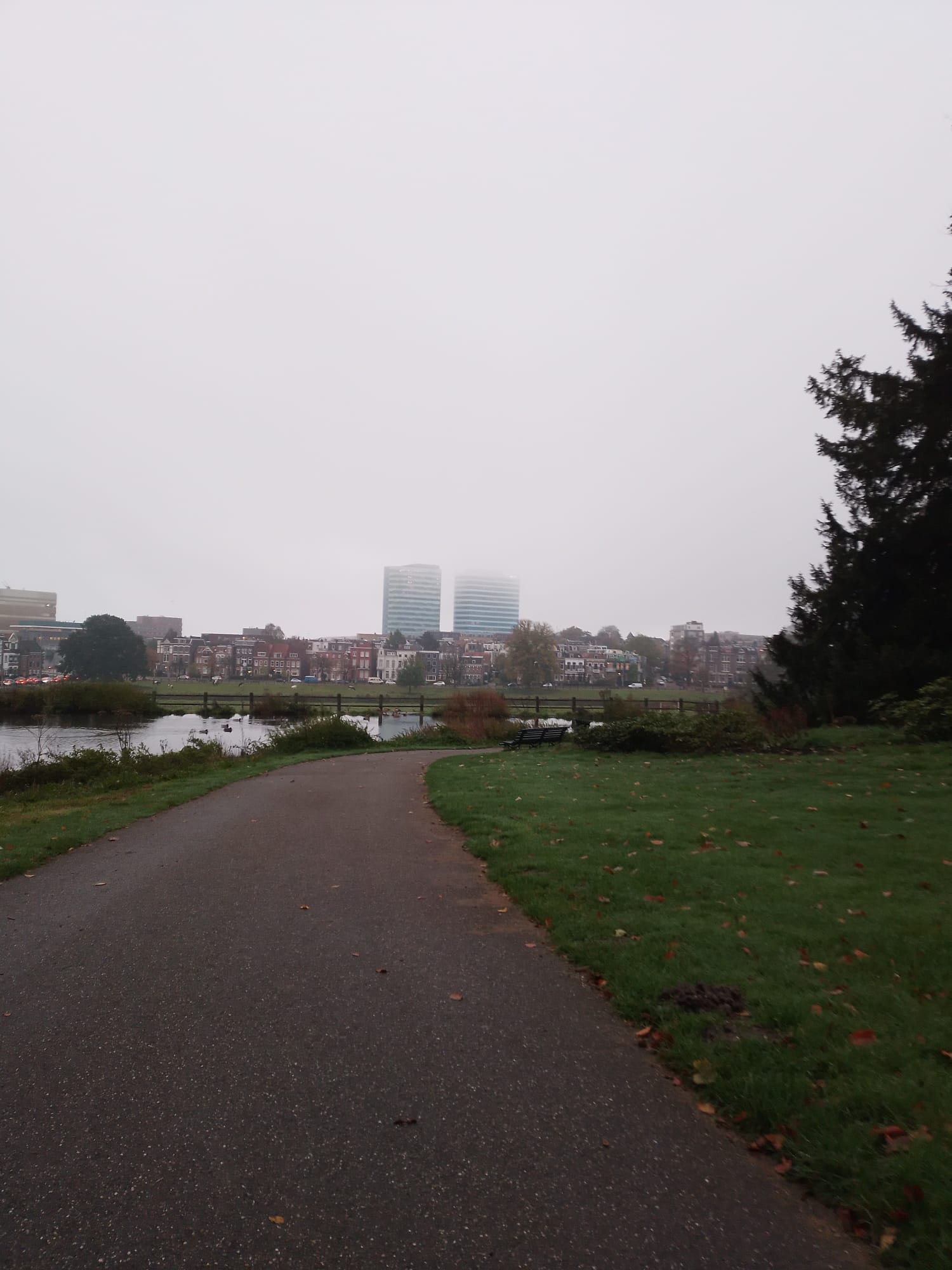 A View of two towers in the distance, covered with mist. Taken from Sonsbeek park.